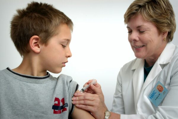 woman inject boy on arm