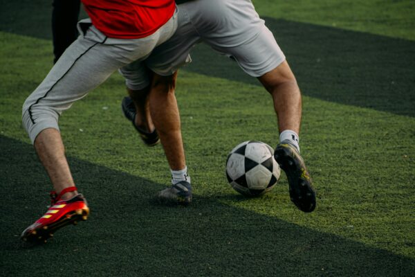 two men are playing soccer on a field