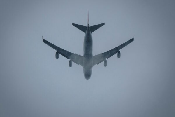 a large jetliner flying through a foggy sky