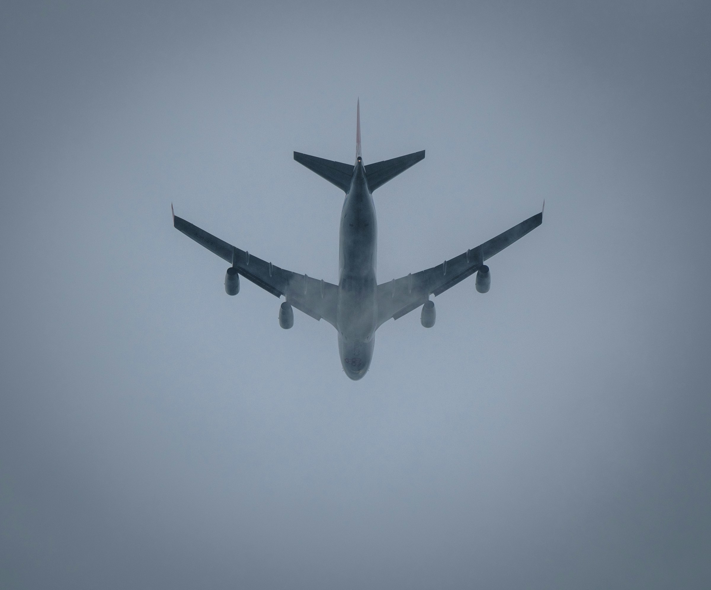 a large jetliner flying through a foggy sky