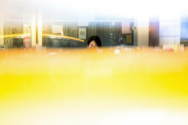 woman in black jacket standing near glass window