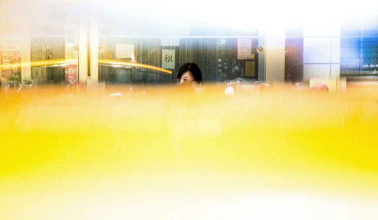 woman in black jacket standing near glass window