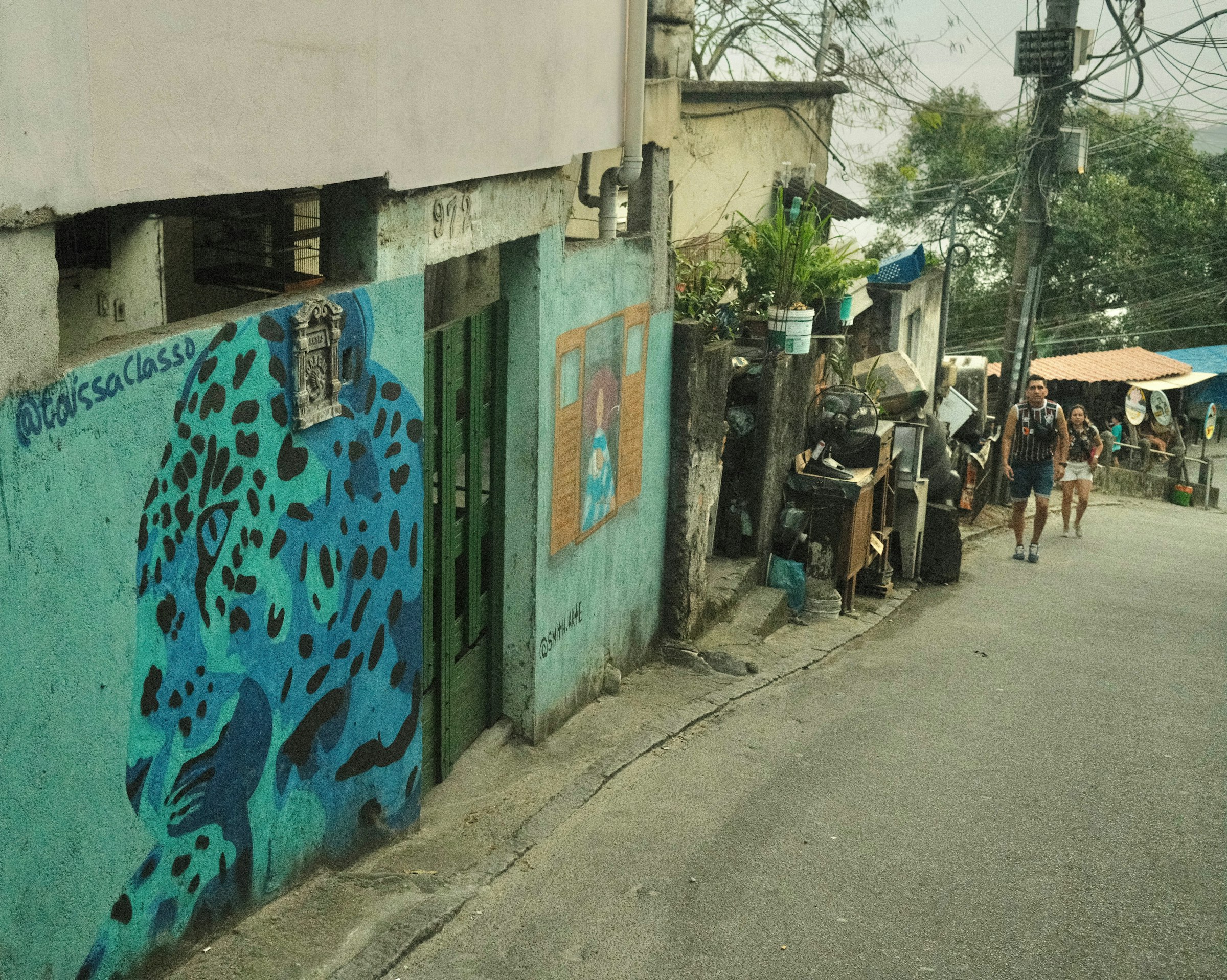 A group of people walking down a street next to a building