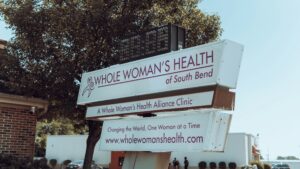 a sign with a tree in the background