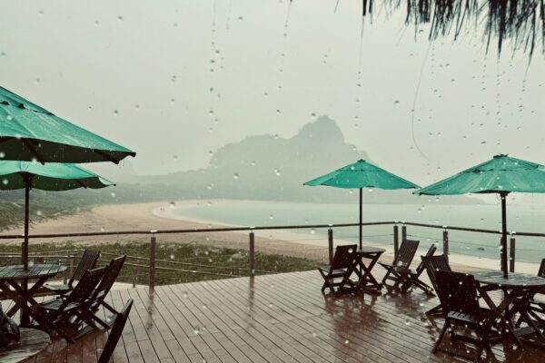 a wooden deck with tables and umbrellas on it