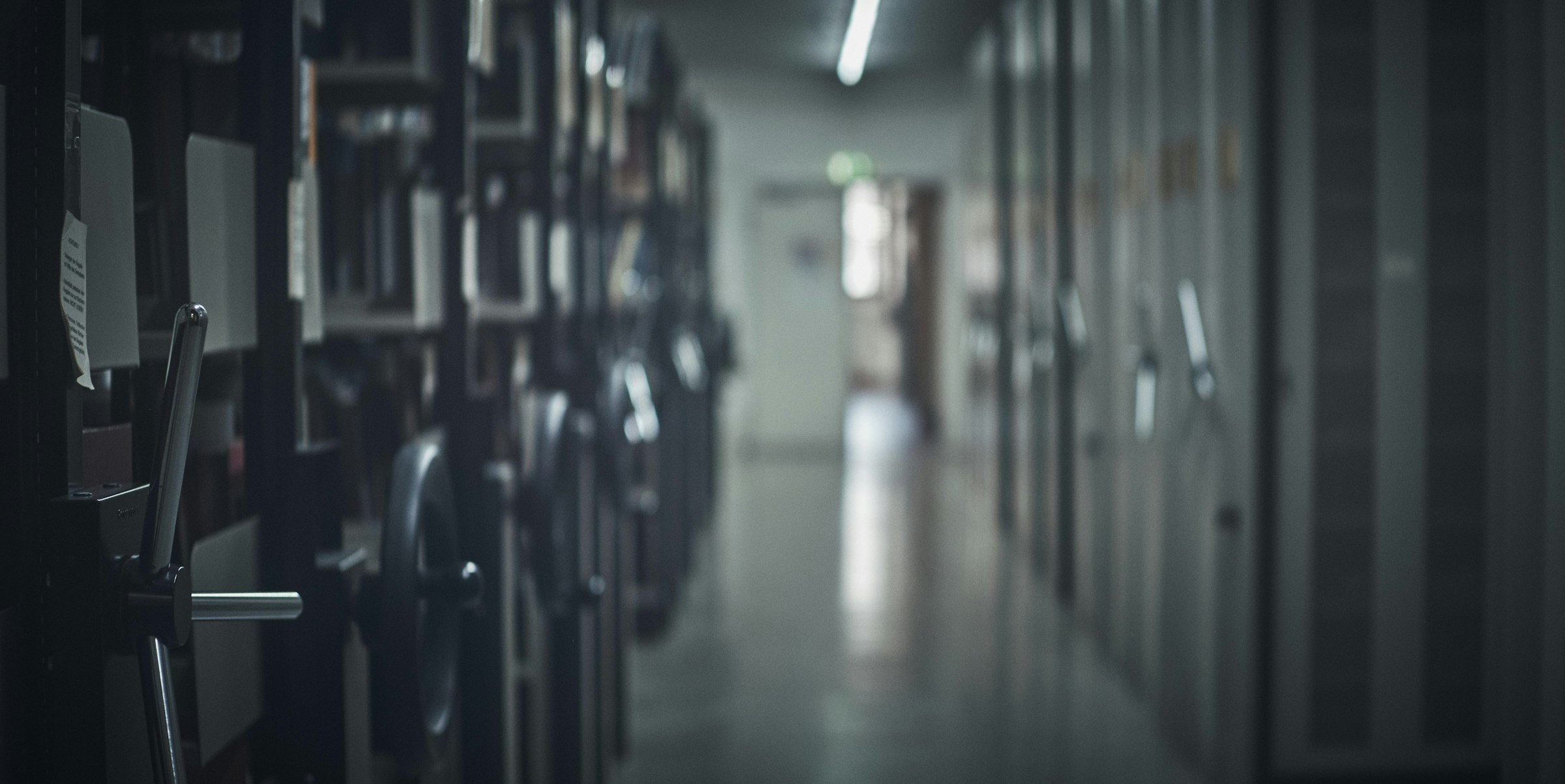 Rows of filing cabinets in a dim, long hallway.