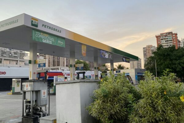 a gas station with trees and buildings in the background