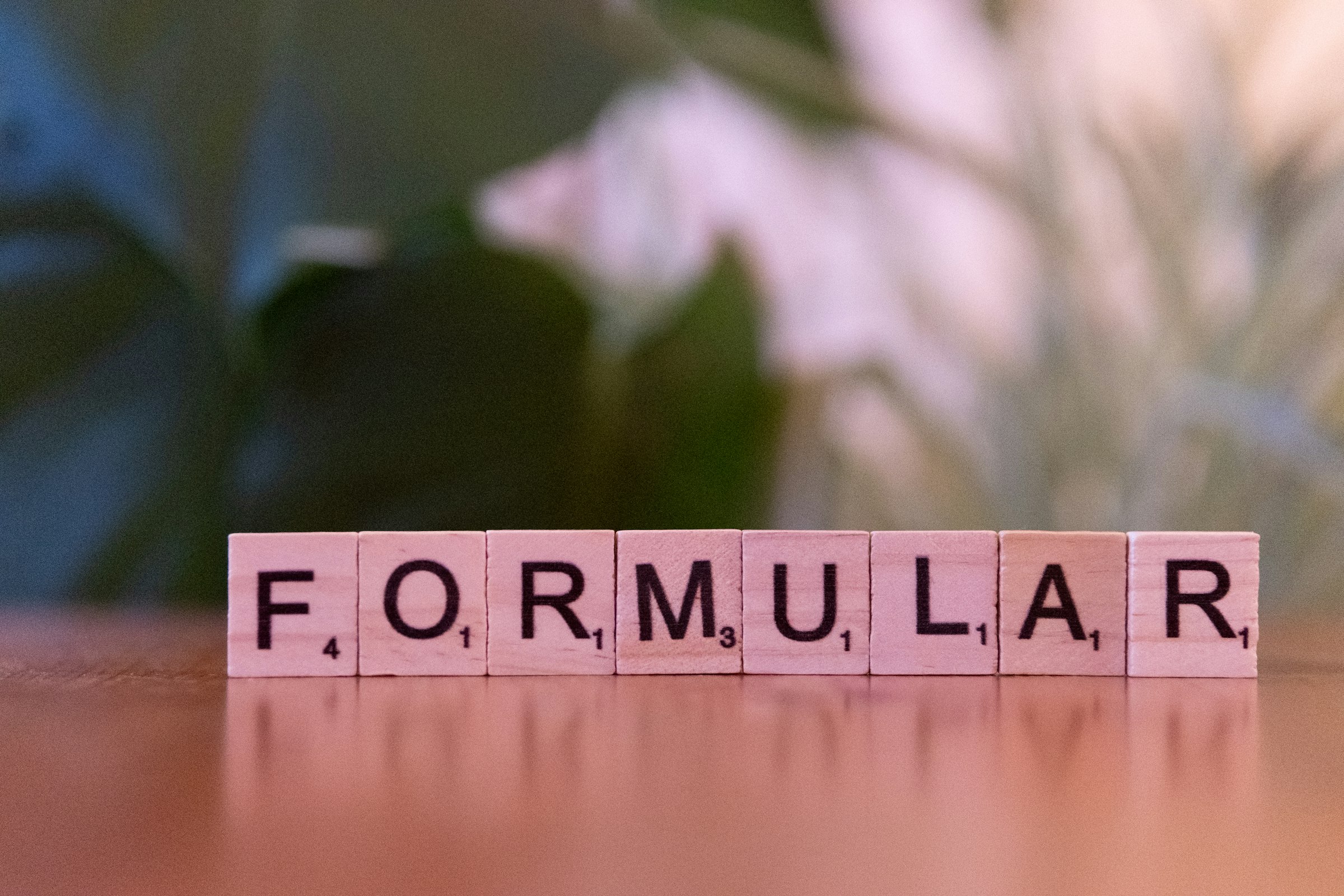 A scrabbled word spelling the word formula on a table
