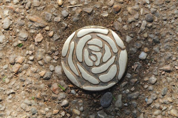a stone with a rose on it laying on the ground