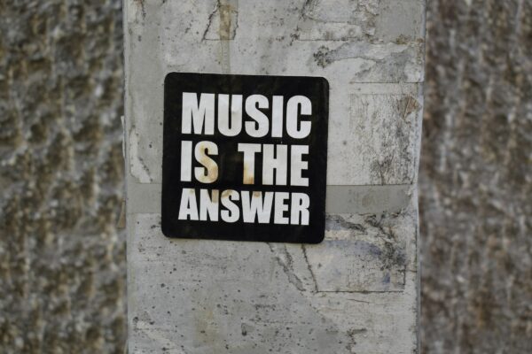 A sign on a wall that says music is the answer