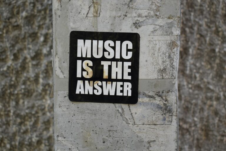 A sign on a wall that says music is the answer
