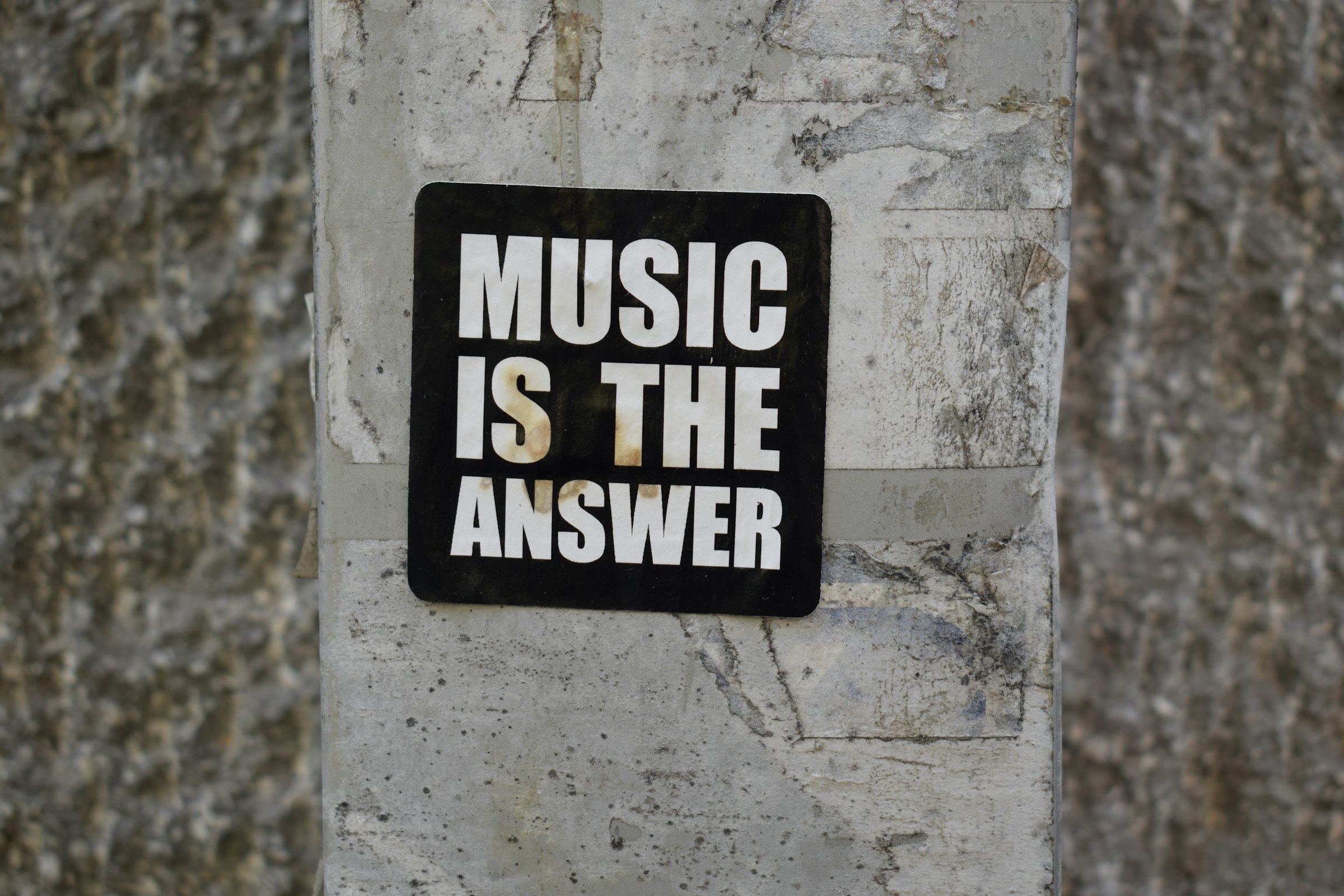 A sign on a wall that says music is the answer