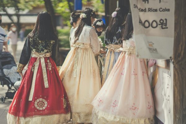 woman in white and red floral dress walking on street during daytime