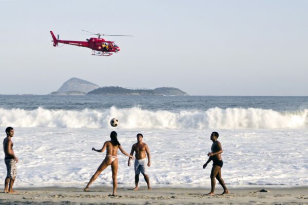 a group of people on the beach playing with a soccer ball